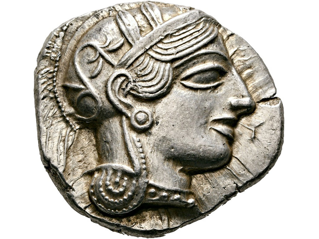 Ancient coin with a profile of a person wearing a headpiece on a white background